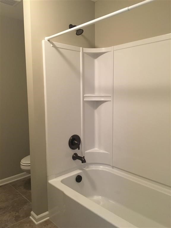 a white bathroom with a shower and a toilet