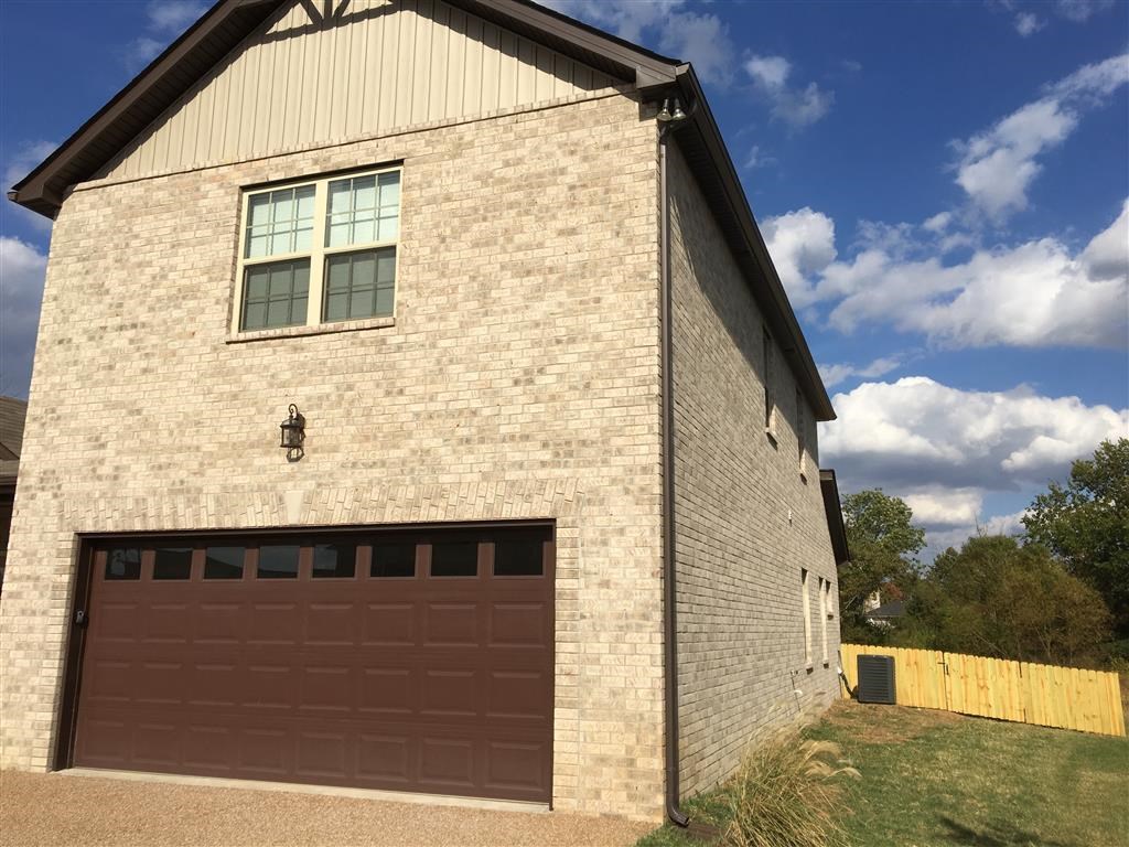a brick house with a brown garage door