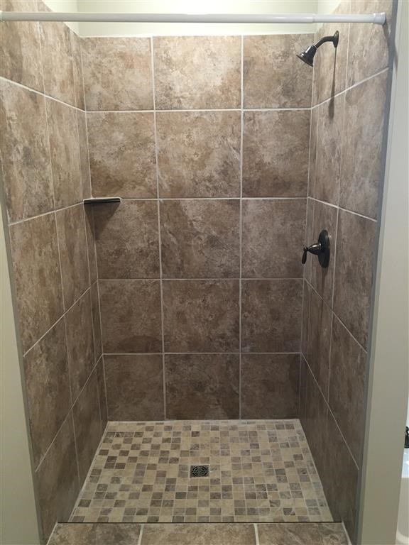 a tiled shower in a bathroom with a shower curtain