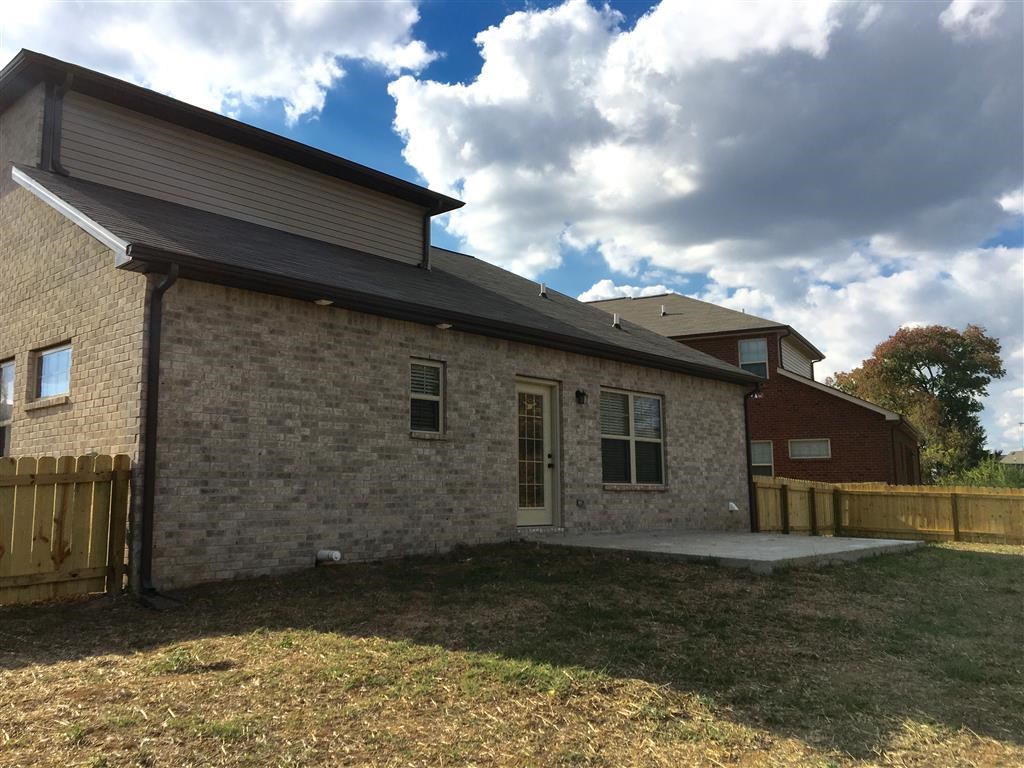 a stone house with a porch and a wood fence