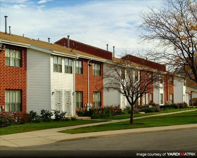 a row of brick and white houses on a street