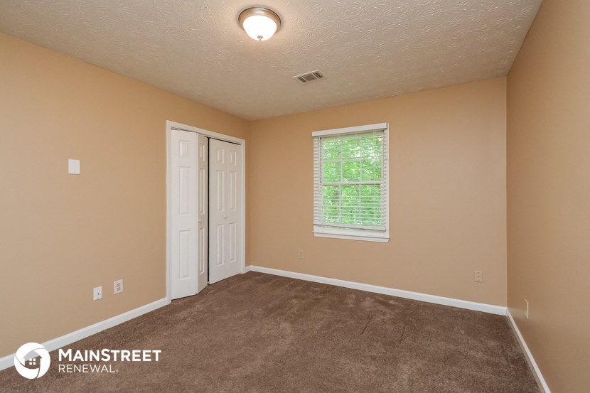 the interior of an empty room with carpet and a window
