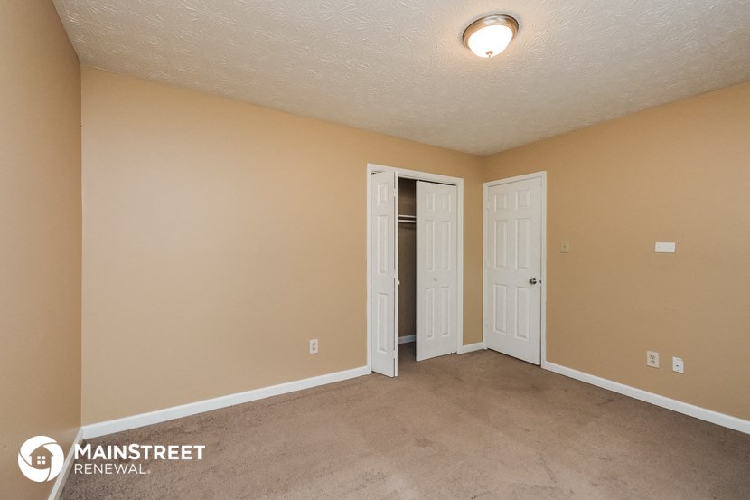 the spacious living room with two doors to the closet