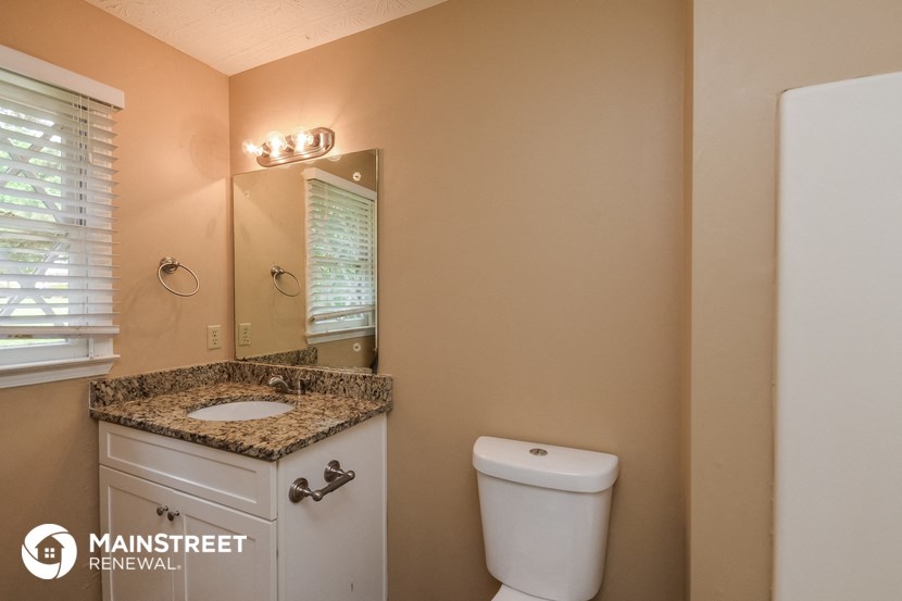 a bathroom with a toilet and a sink and a mirror
