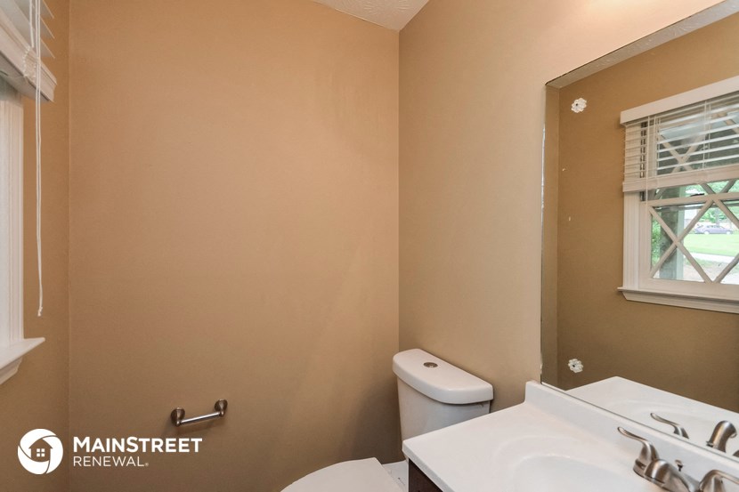 a bathroom with a toilet and a sink and a window