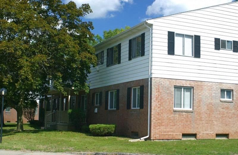 a brick and with a tree in front of it