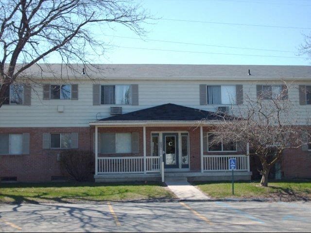 a white and brick house with a front porch