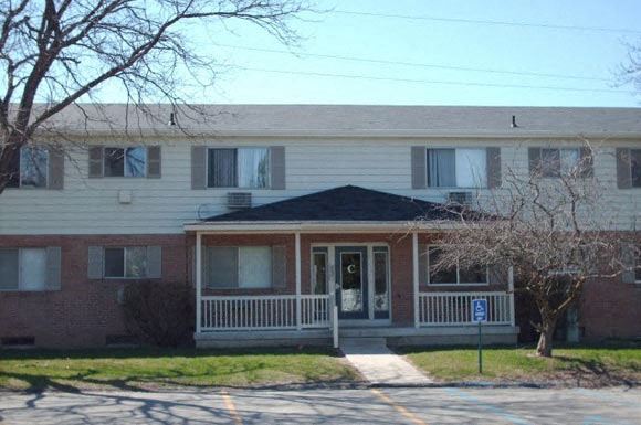a house with a porch and a tree in front of it