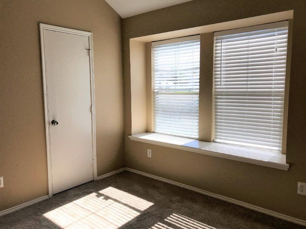 a small room with two windows and a door