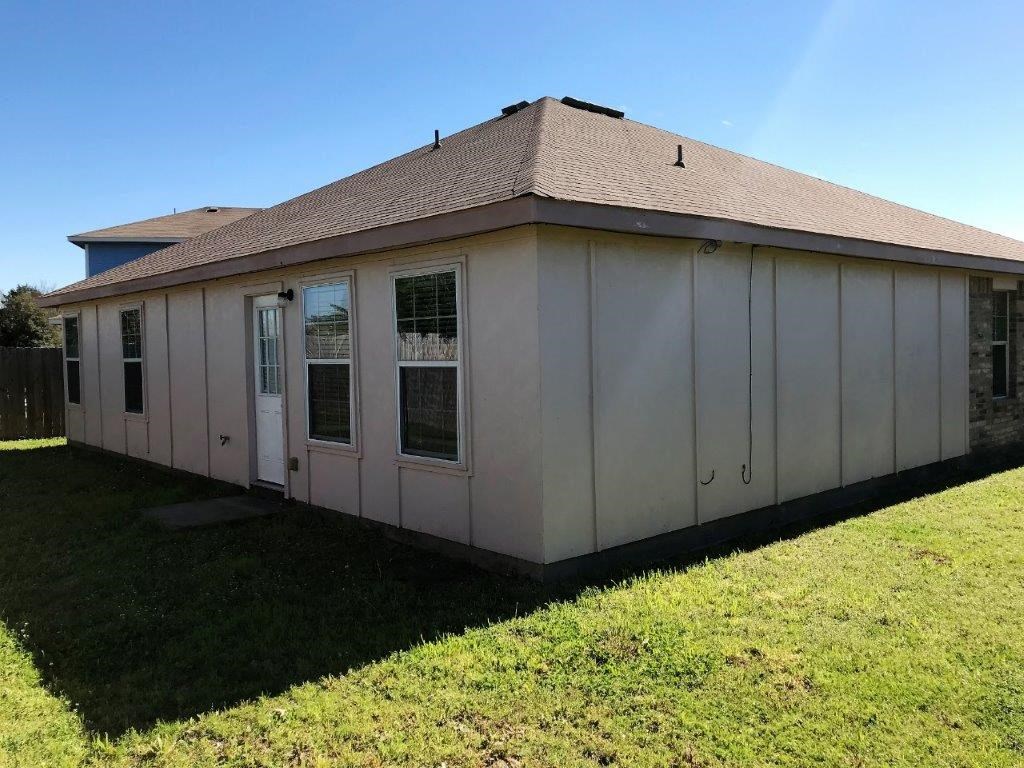 a white house with a brown roof on a lawn