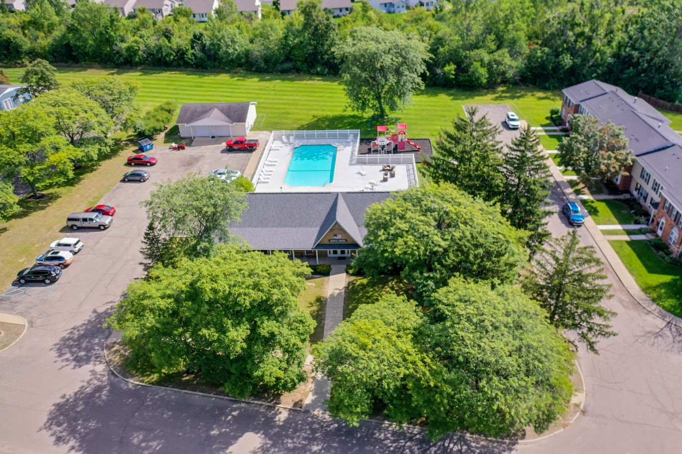 an aerial view of a house with a swimming pool and a parking lot