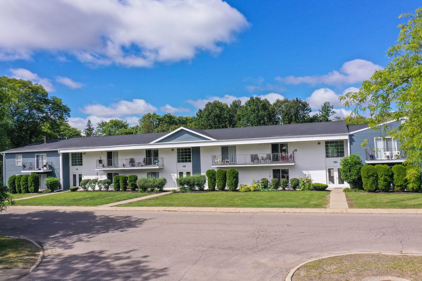 a large white house with a lawn and trees in front of it