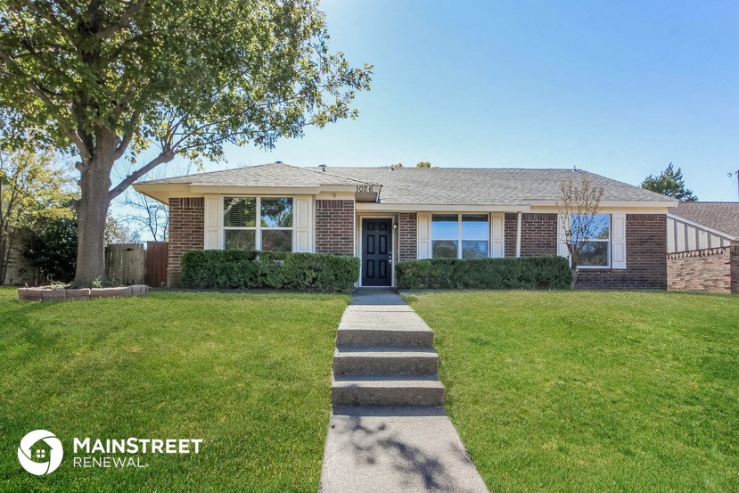 a house with a lawn and a sidewalk in front of it