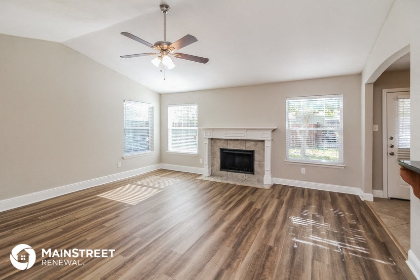 the living room with wood flooring and a fireplace