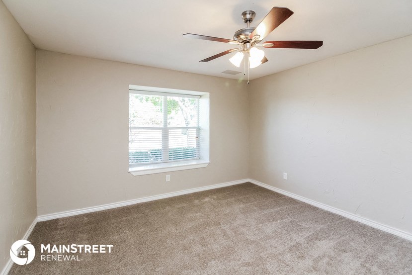 a bedroom with a ceiling fan and a window