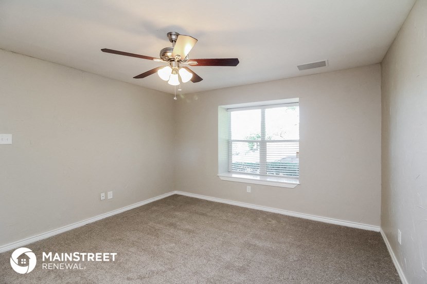 a bedroom with a ceiling fan and a window