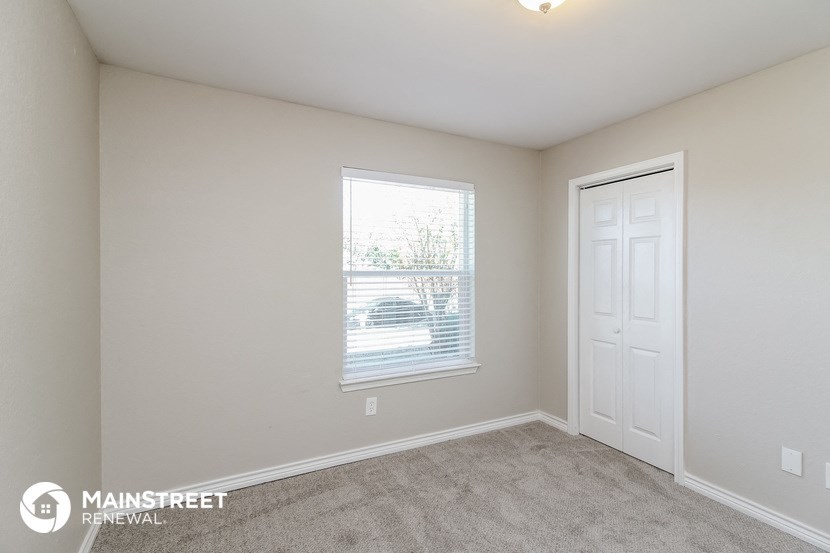 a bedroom with a window and a white door