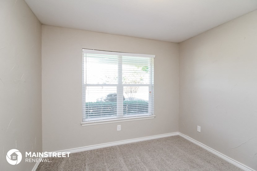 the bedroom of a rental house with a large window