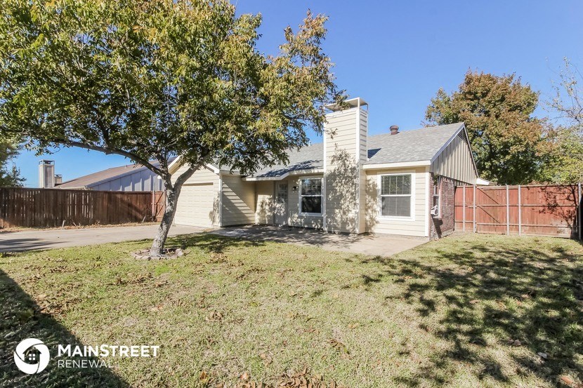 a small white house with a yard and a tree
