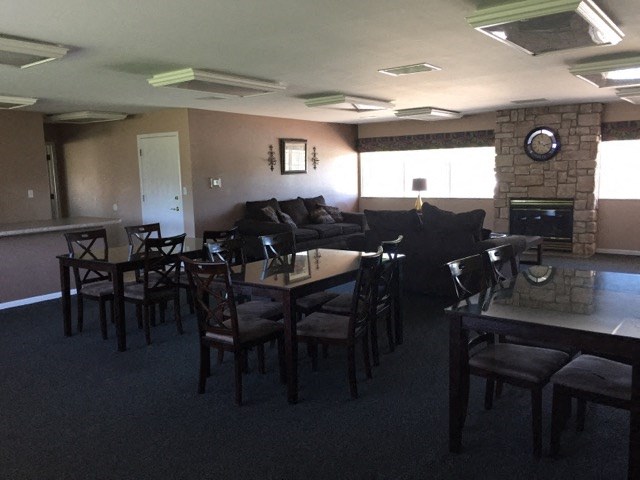 a living room with tables and chairs and a fireplace