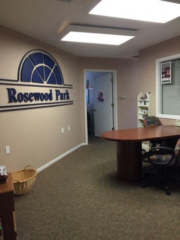 a office with a table and a rosswood apt sign on the wall