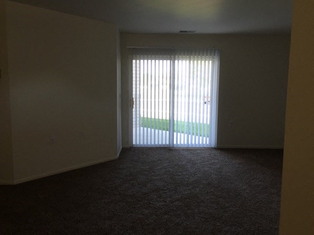 an empty living room with a sliding glass door