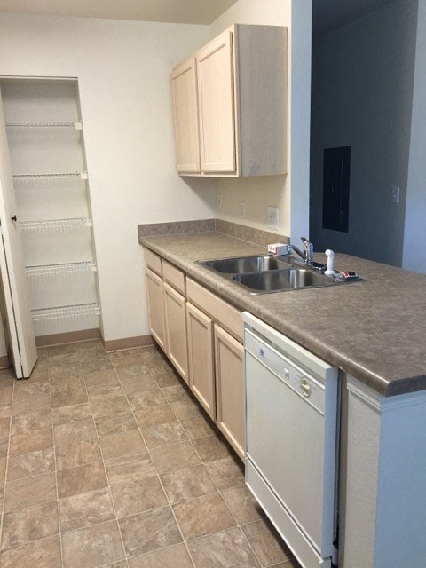 an empty kitchen with a sink and cabinets