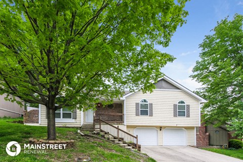 a white house with a tree in front of it