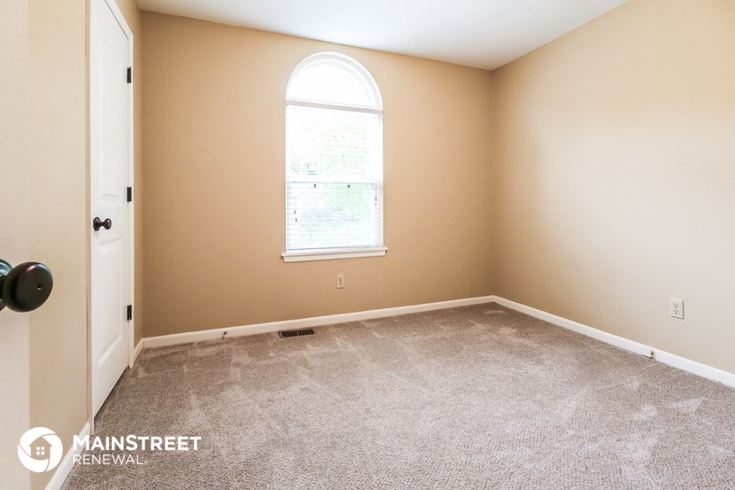 an empty room with carpet and a window