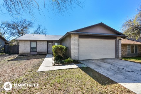 a small brick house with a white garage door