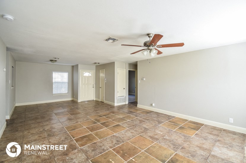 the living room with tile flooring and a ceiling fan