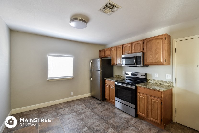 a kitchen with wooden cabinets and stainless steel appliances