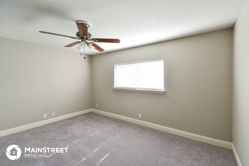 a bedroom with a ceiling fan and a window