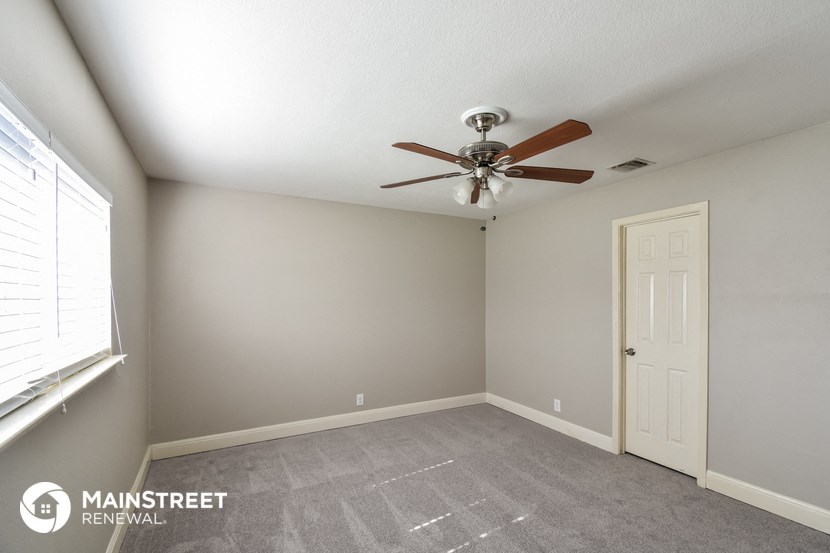 a bedroom with a ceiling fan and a window