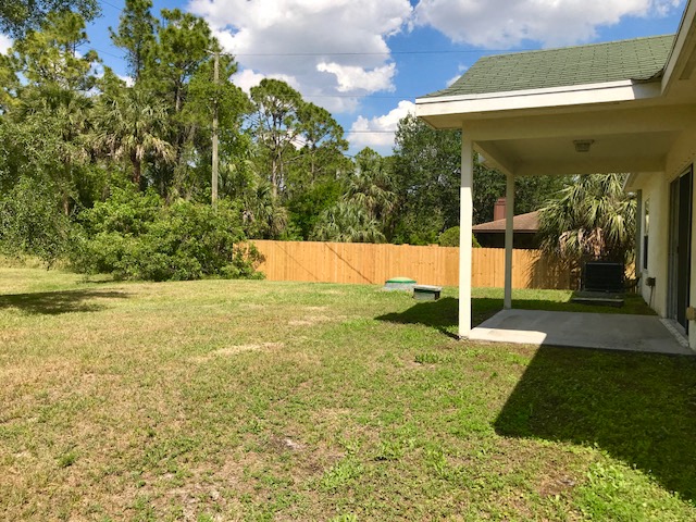 a yard with a house and a fenced in yard