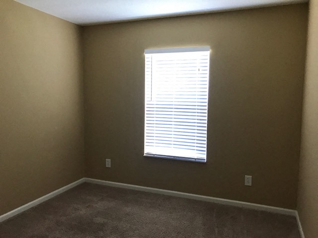 a empty room with a window and a carpet