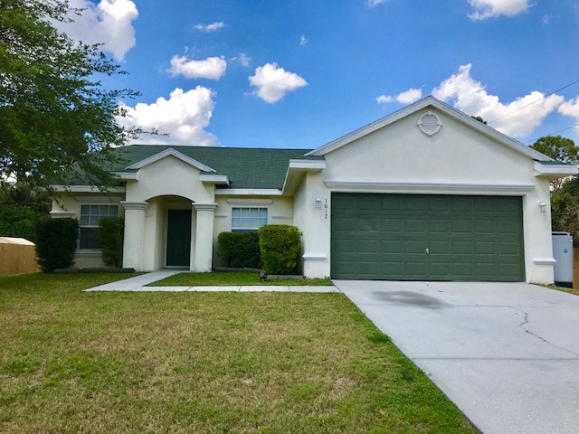 a white house with a green garage door