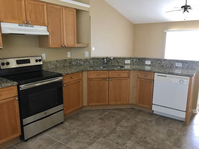 an empty kitchen with a stove and a sink