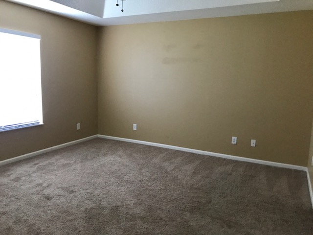 an empty room with carpet and a window