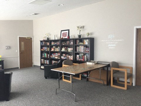 a room with a table and chairs and a book shelf