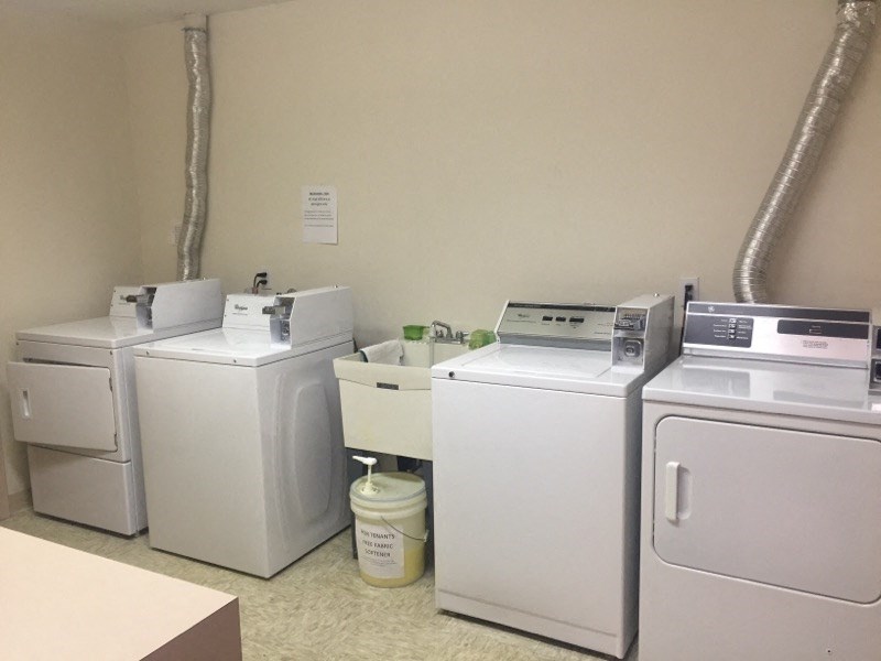 four washing machines are lined up next to each other in a room