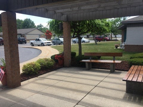 a covered patio with a bench and a picnic table