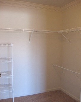 a empty closet with hanging racks on the wall
