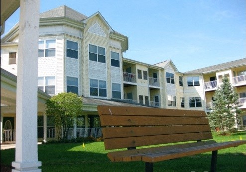 a wooden bench in front of an apartment building