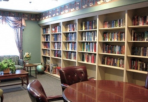 a library with a table and chairs and shelves of books