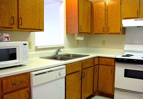 a kitchen with white appliances and wooden cabinets