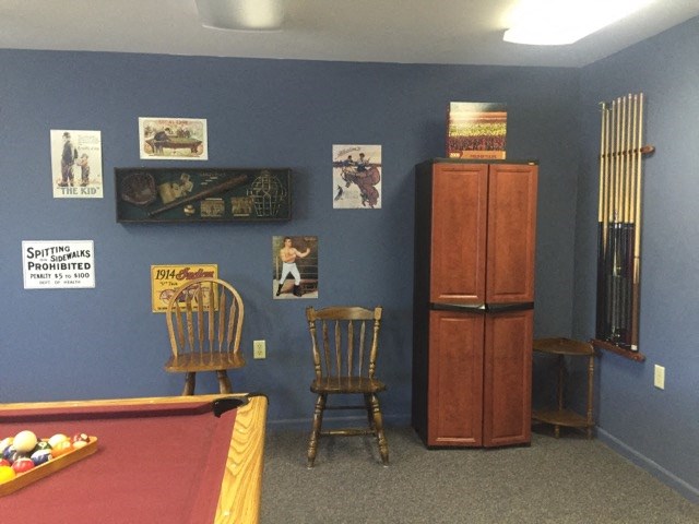 a game room with a pool table and chairs