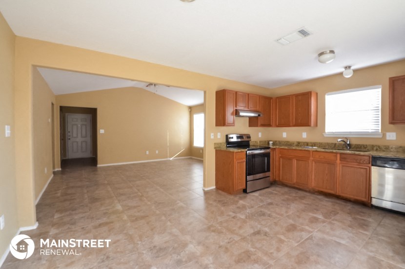 a kitchen with wood cabinets and stainless steel appliances