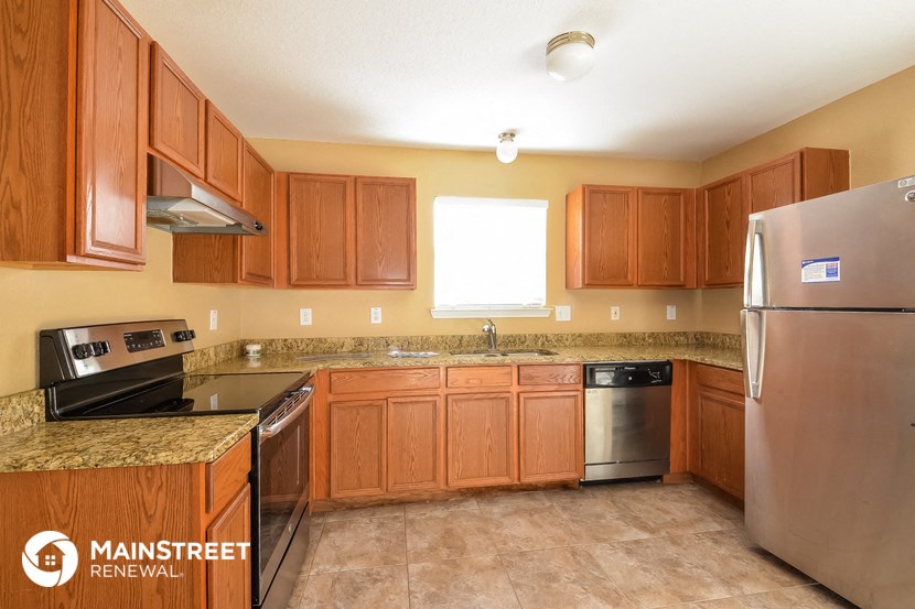 a kitchen with wooden cabinets and stainless steel appliances