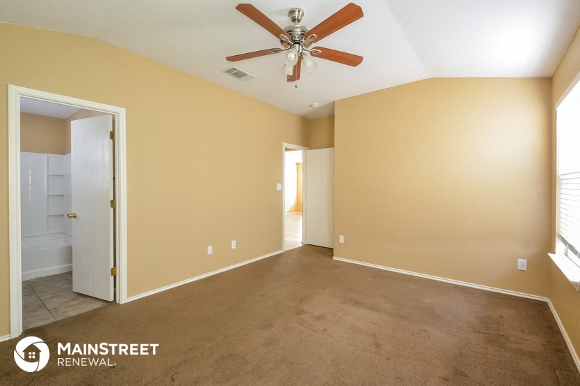 the living room with carpet and a ceiling fan